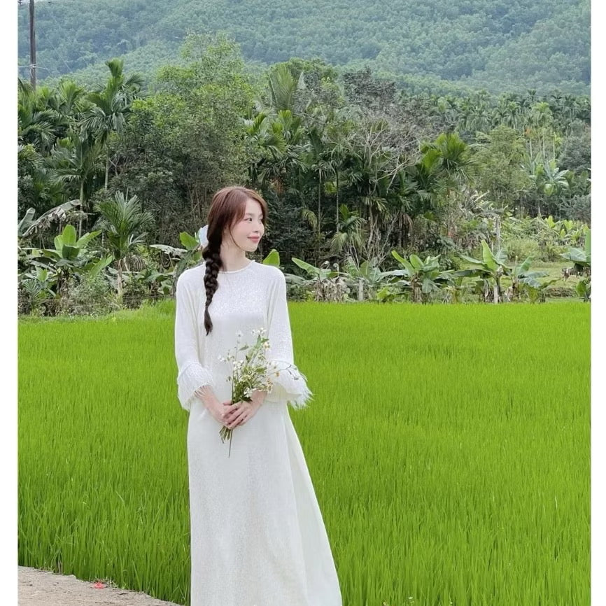 Áo dài gấm dáng xuông tay loe đính viền lông vũ