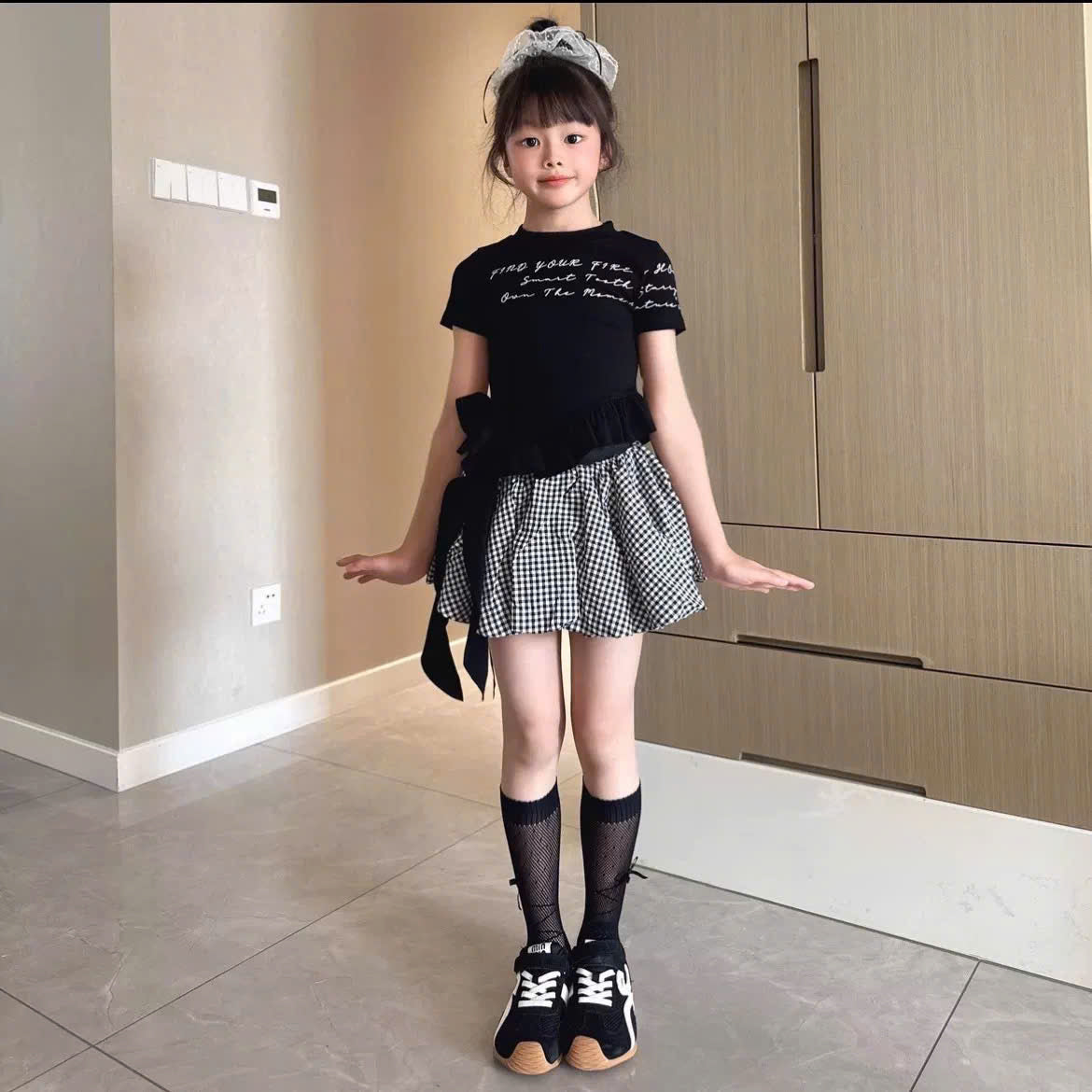 Áo phông cột nơ tua rua phối chân váy caro